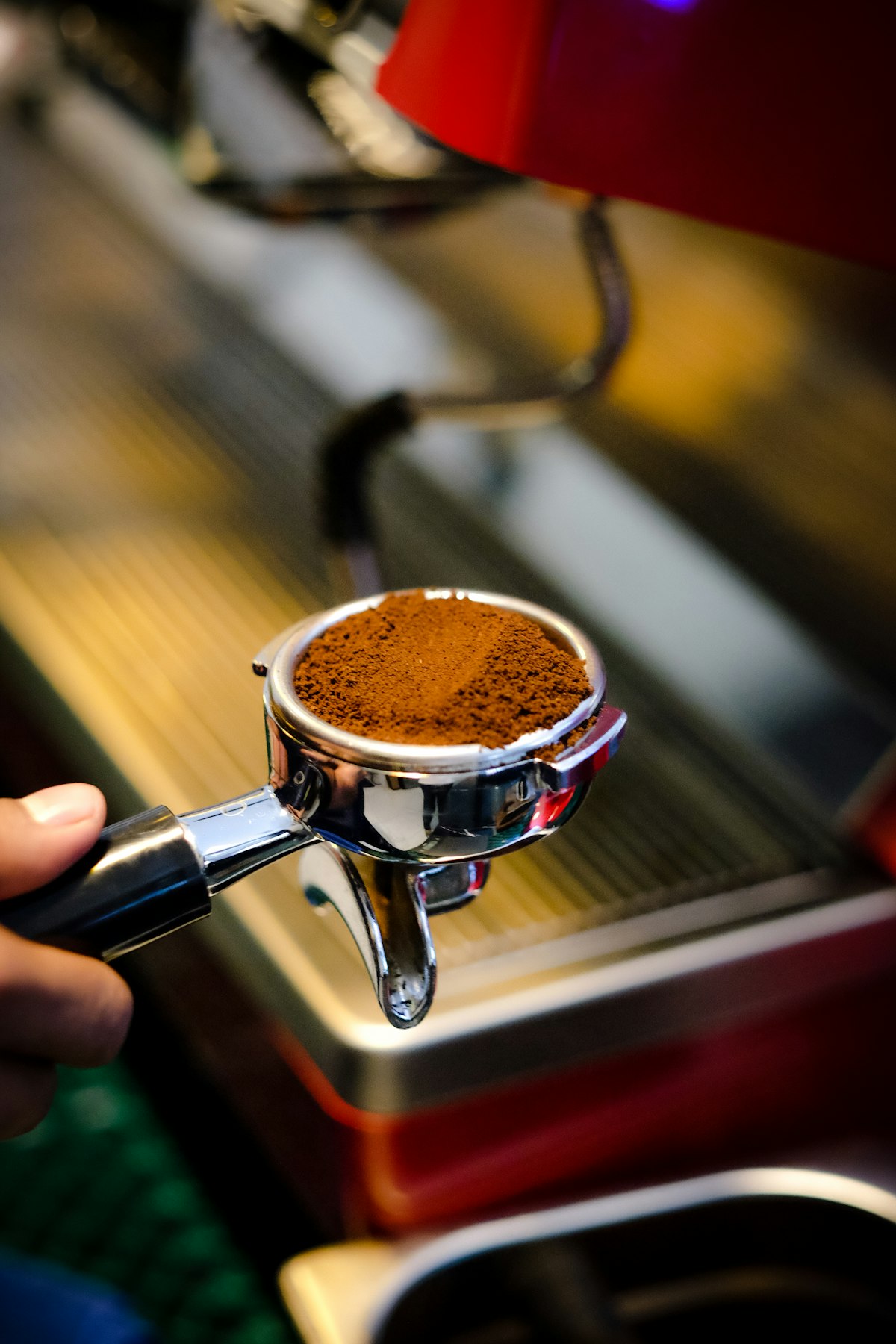 Barista drží portafilter s mletou kávou