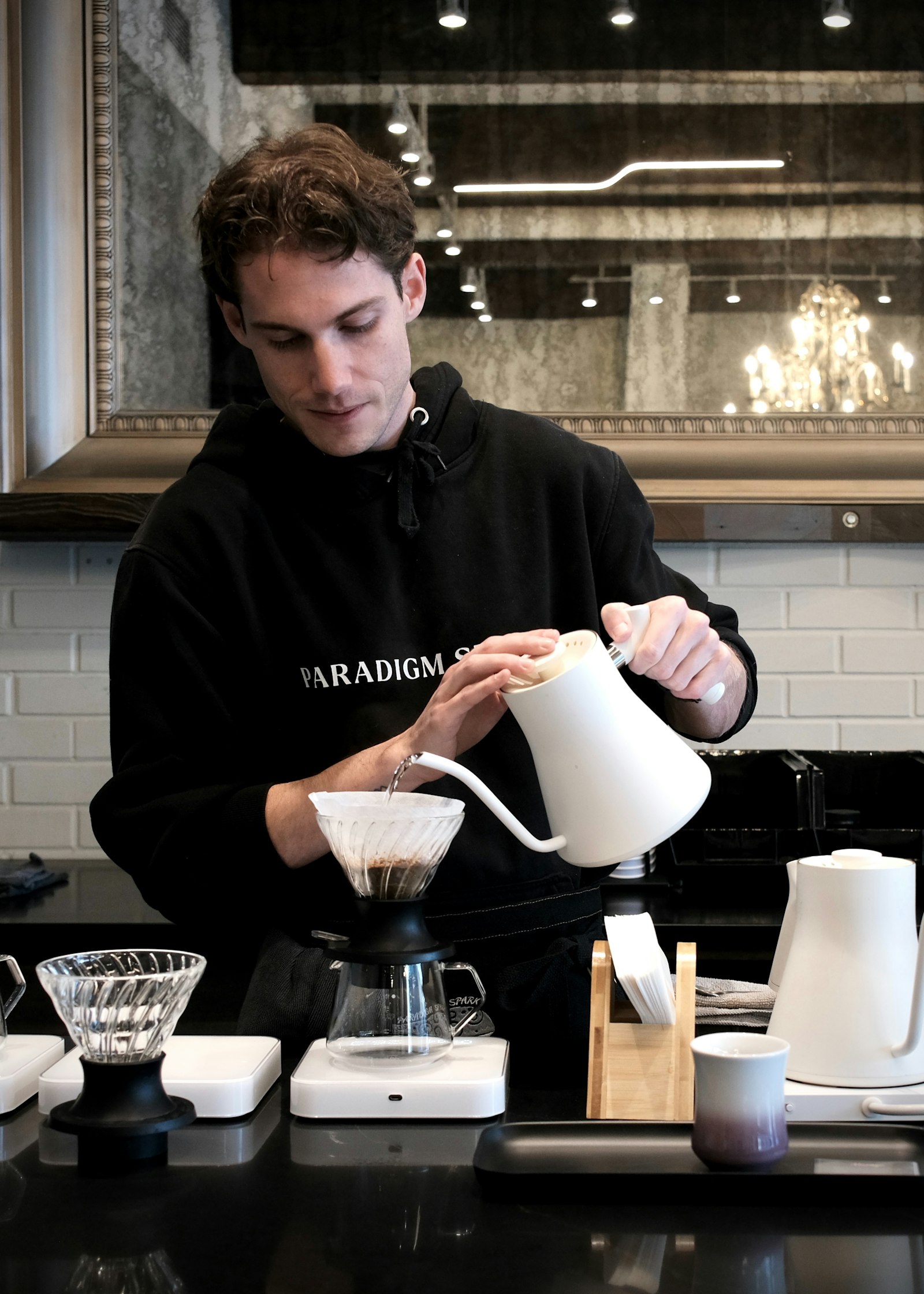 Barista pomaly leje horúcu vodu do kávového drippera